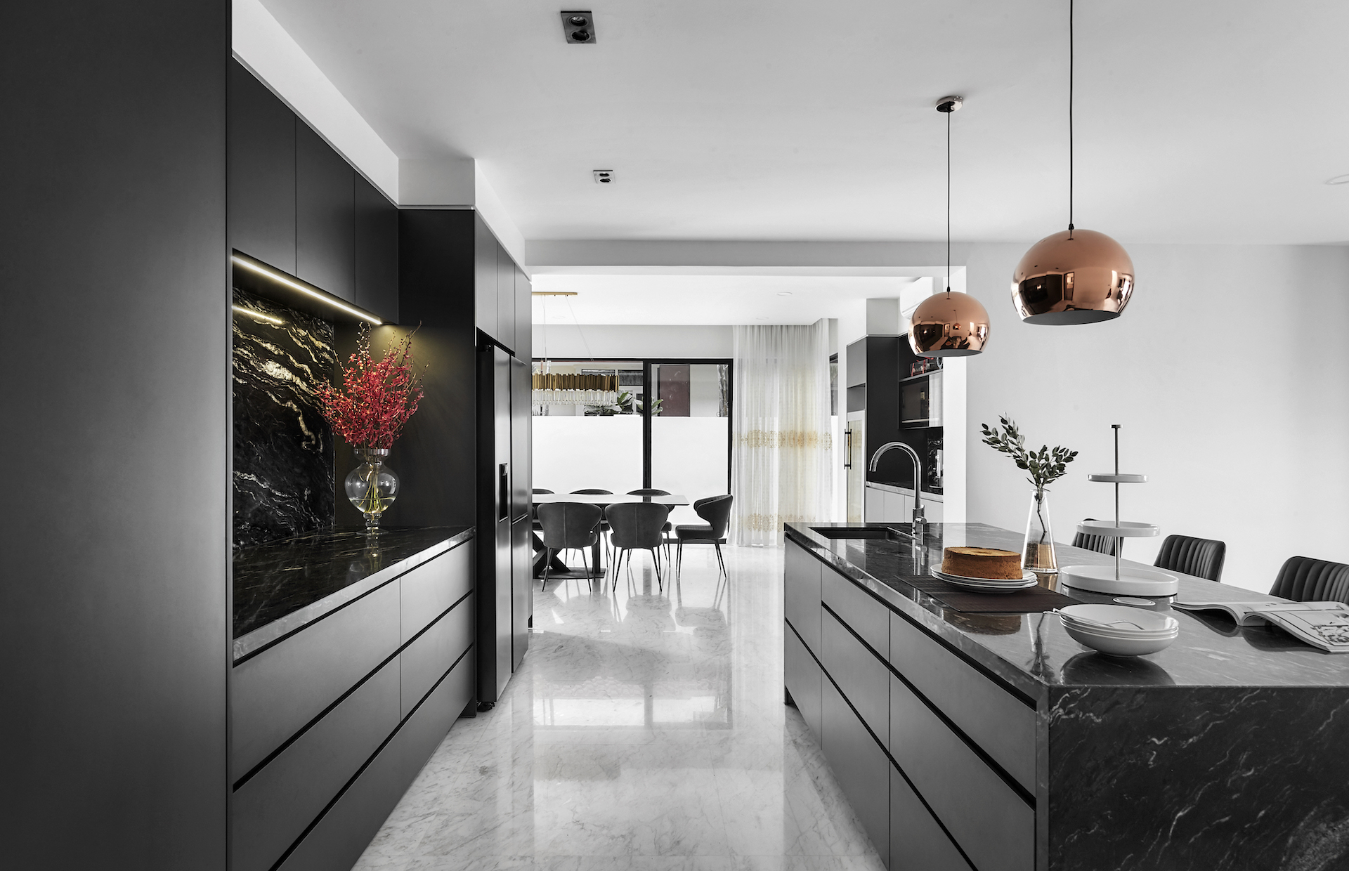 A black and white kitchen with marble counter tops.