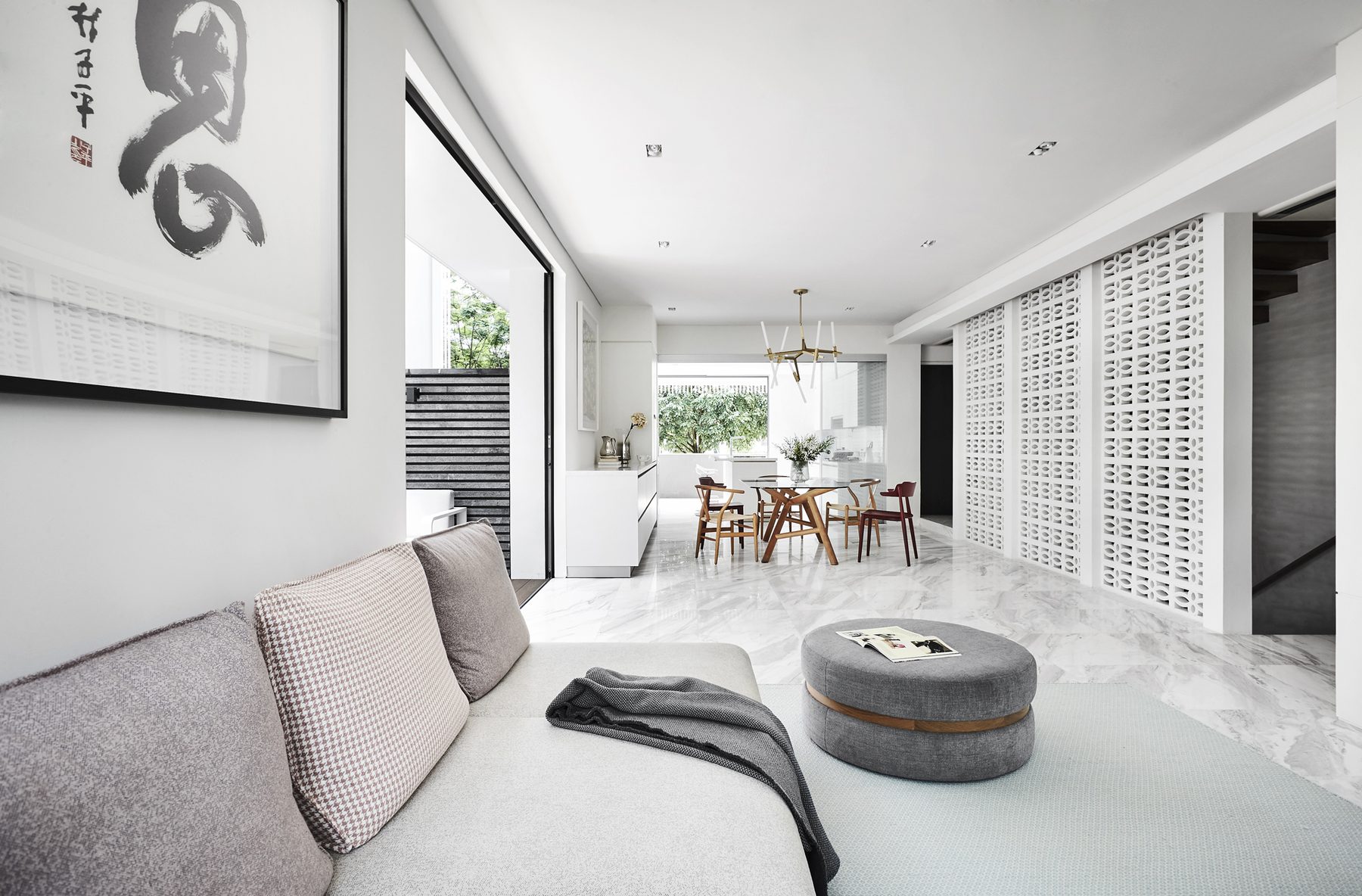 Open-plan living and dining area with a white patterned screen wall and marble floor, Old Holland Road (2018)