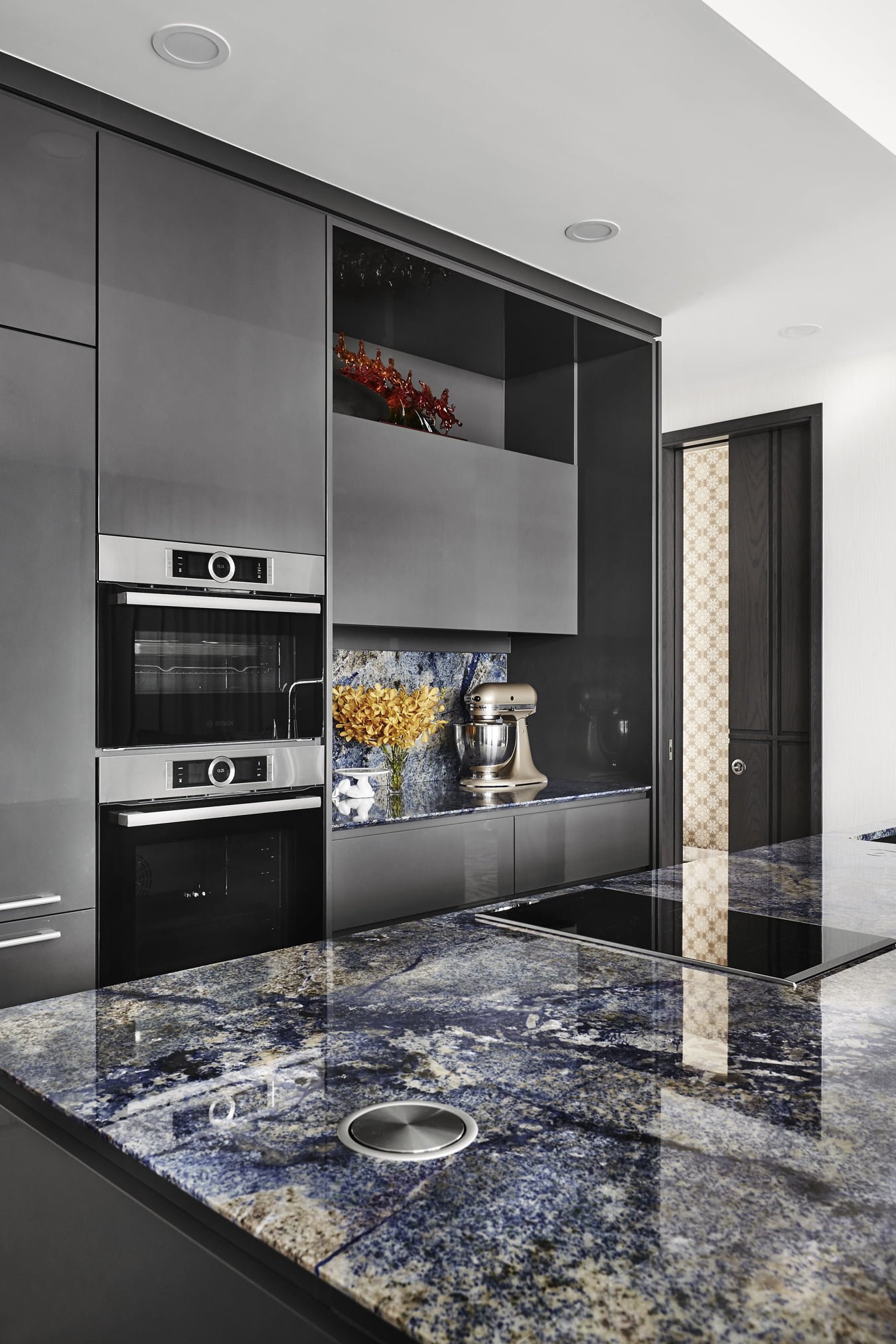 A modern kitchen with blue granite counter tops.