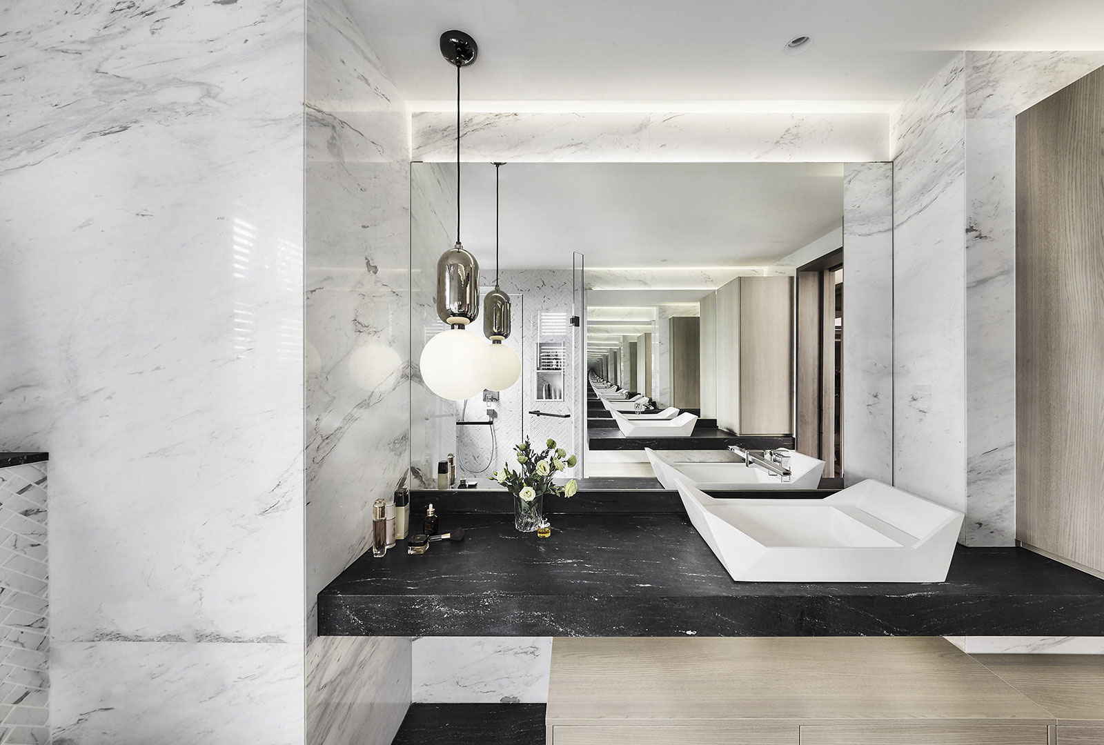 A bathroom with marble counter tops and a black sink.