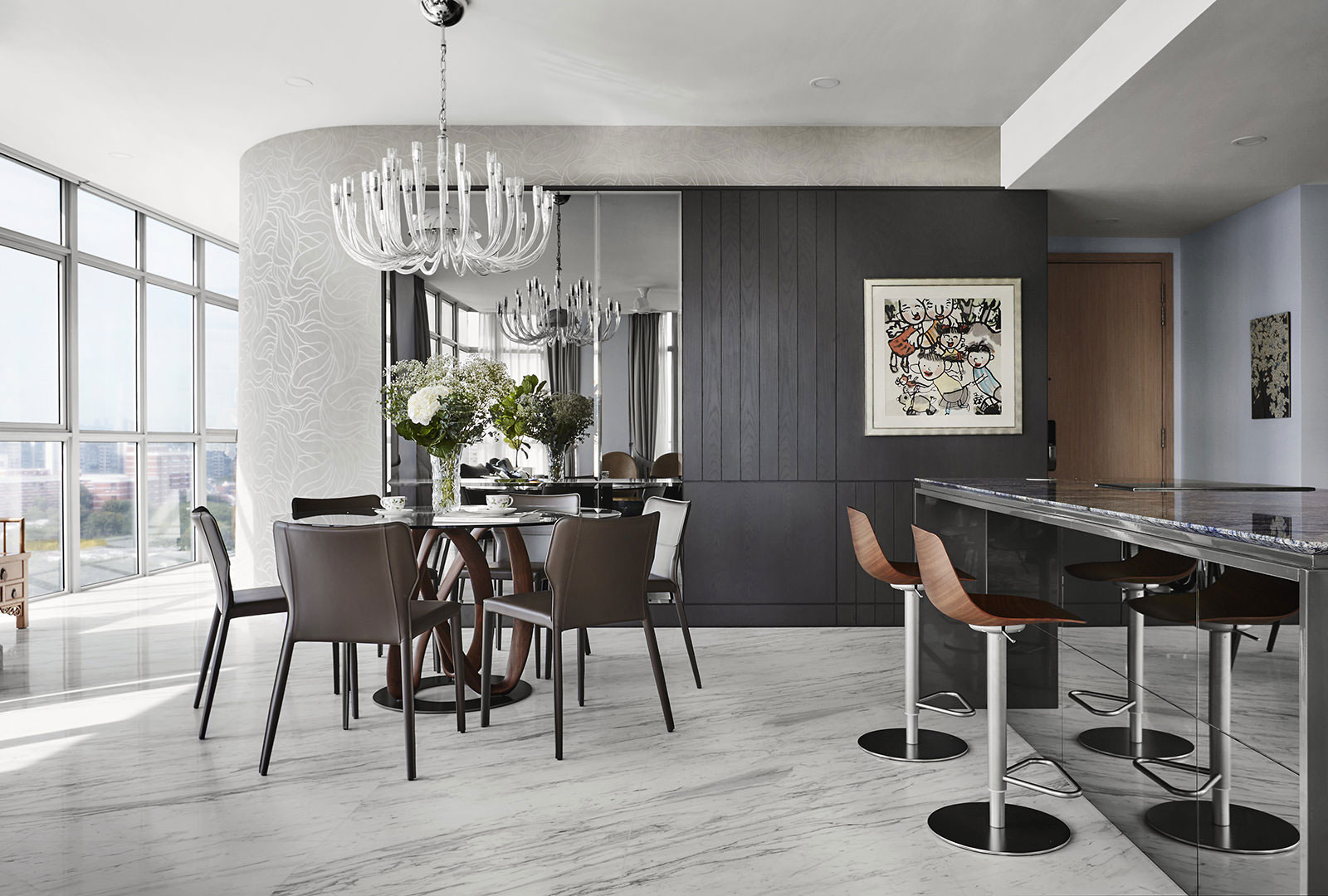 A modern kitchen with marble counter tops and a dining table.