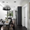 A black and white dining room with a cat hanging above the table.