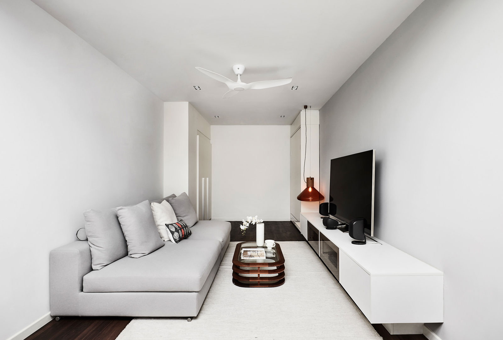 A living room with a white couch and tv.
