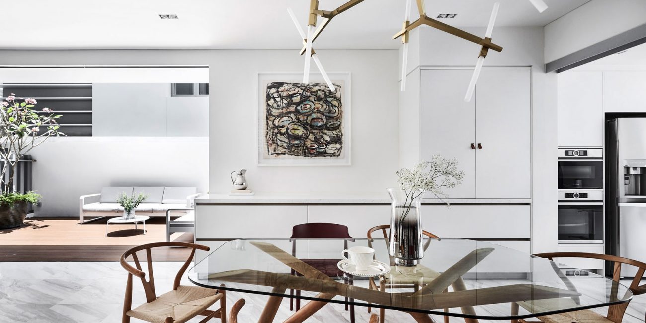 A dining room with a glass table and chairs.