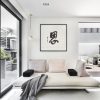 A living room with a white couch and chinese art on the wall.