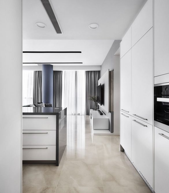 A modern kitchen with white cabinets and marble counter tops.