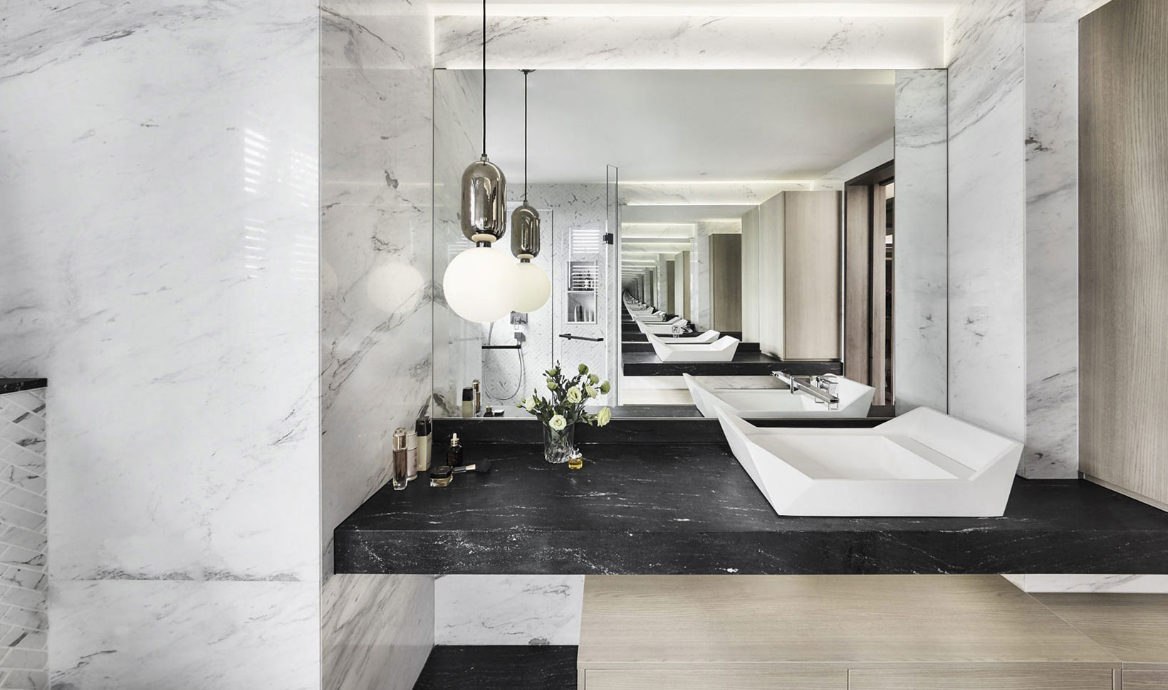 A marble bathroom with a sink and mirror.