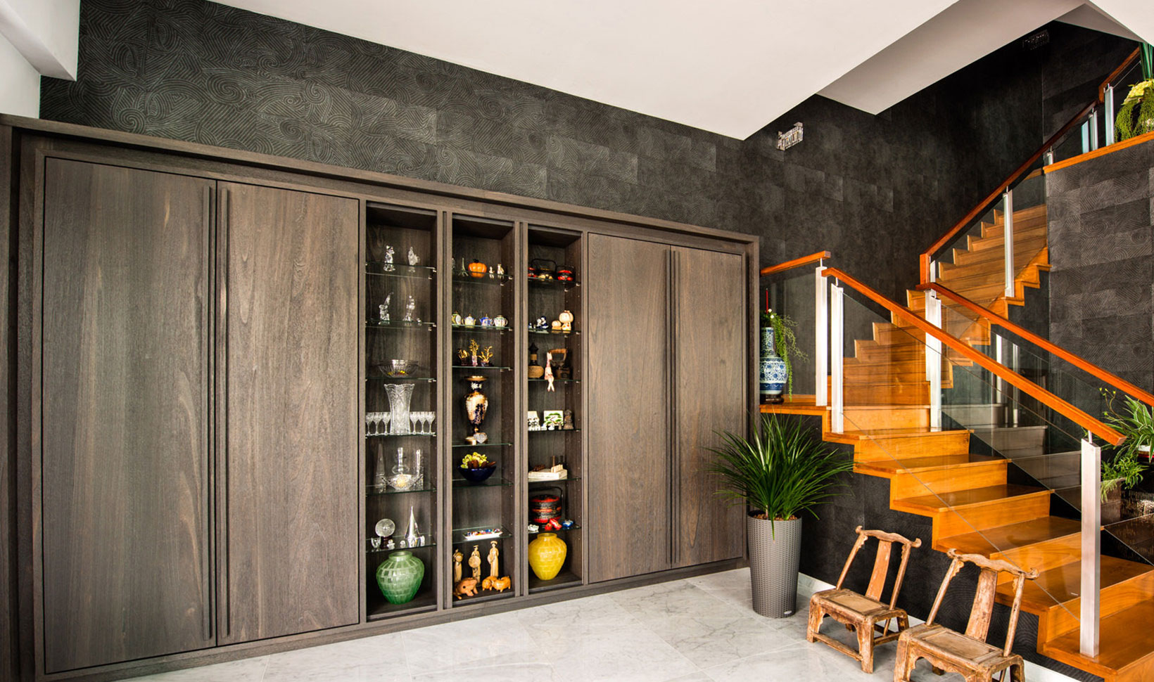 A living room with a wooden cabinet and stairs.