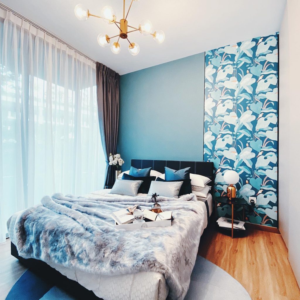 A blue and white bedroom with a bed and a chandelier.