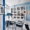 A blue and white dining room with a white table and chairs.