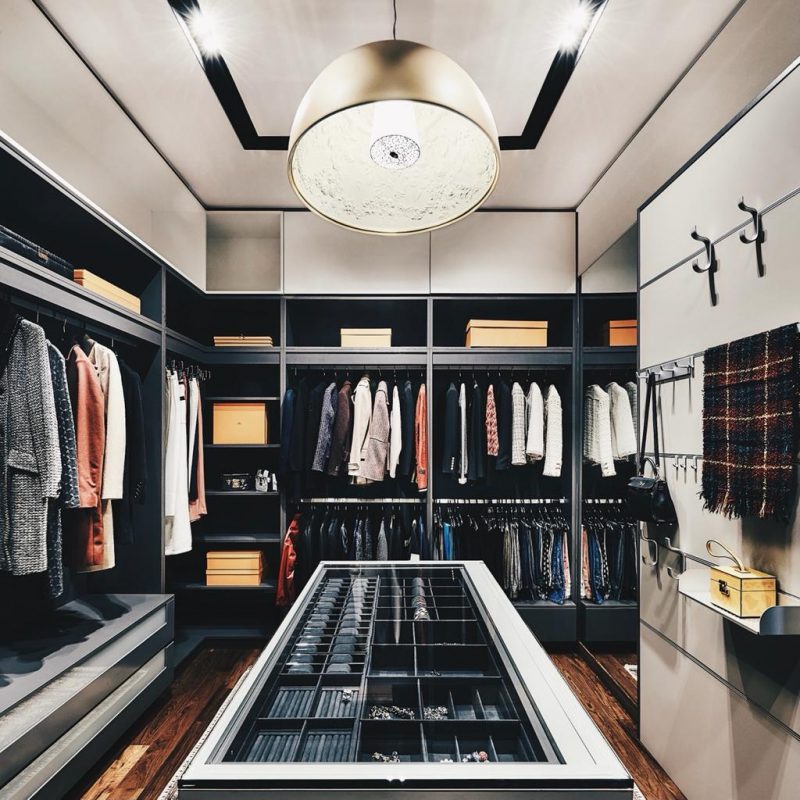 A walk in closet with a lot of clothes.