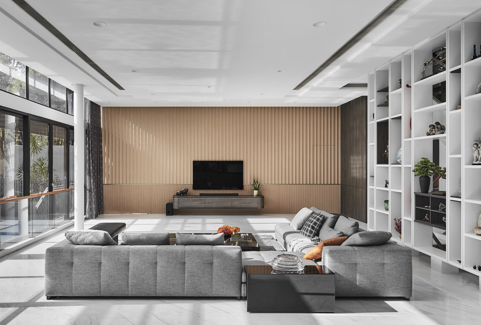 A modern living room with large windows and white furniture.