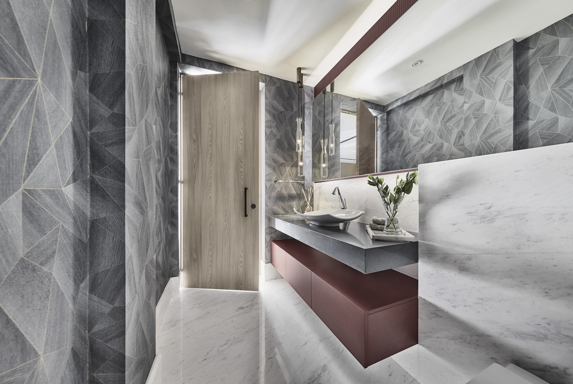 A bathroom with marble walls and a marble sink.