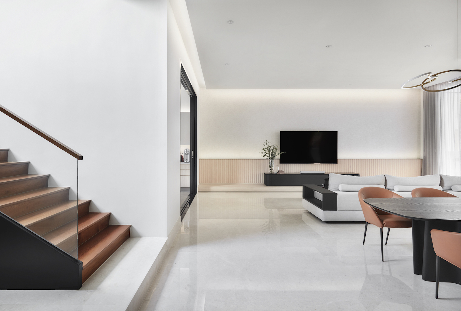 A modern living room with stairs and a television.