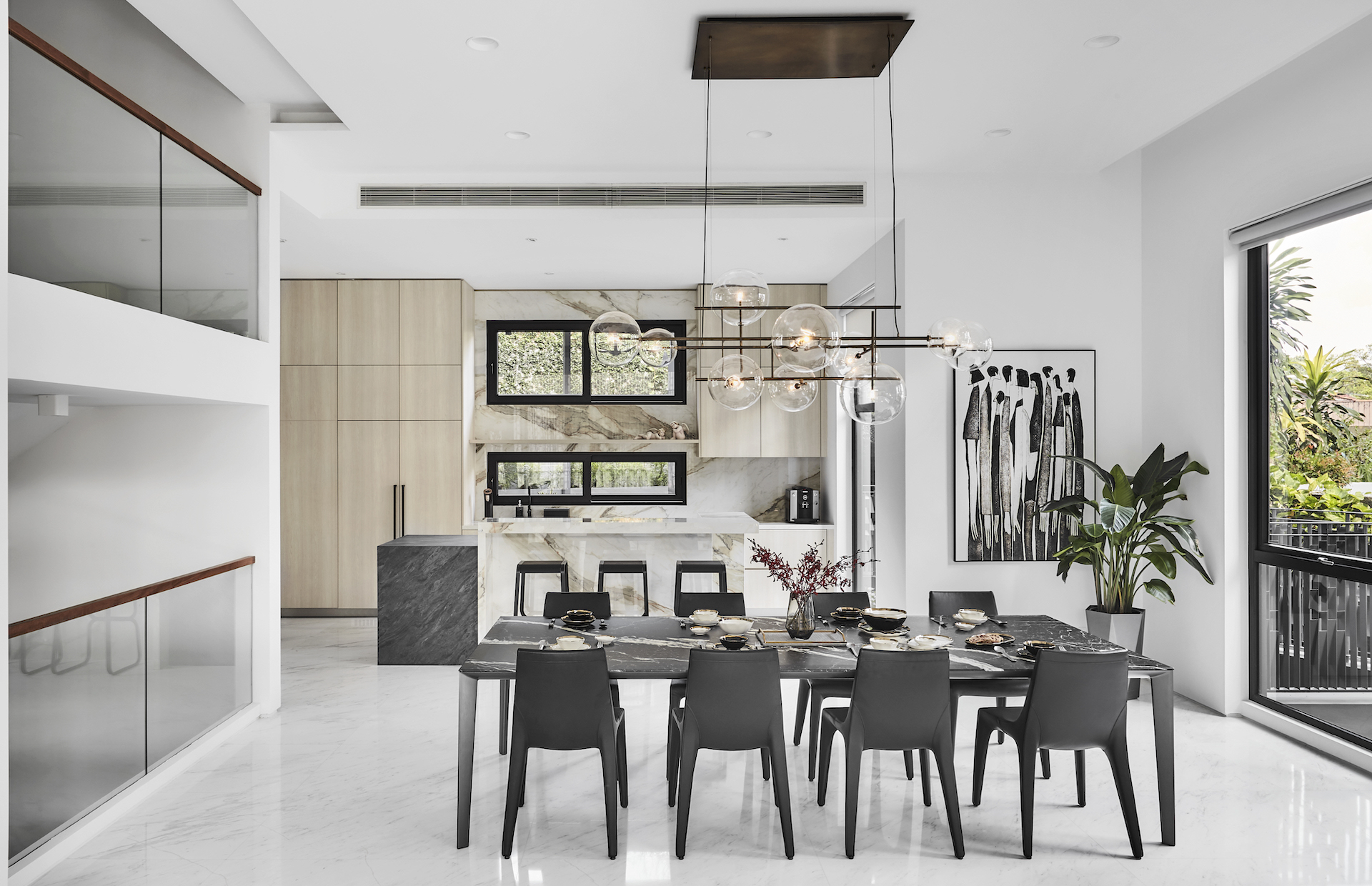 A modern dining room with a black table and chairs.